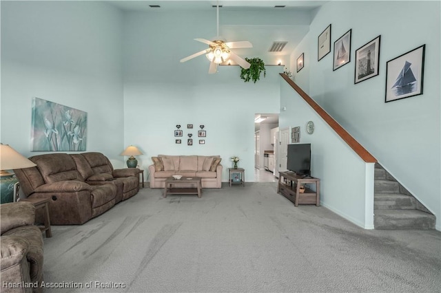 living room with carpet flooring, ceiling fan, and a high ceiling