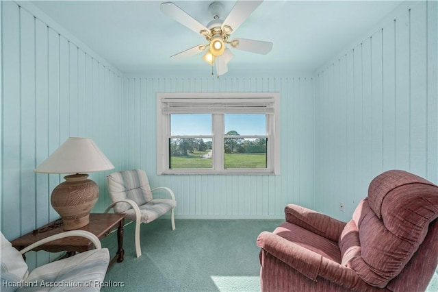 living area with ceiling fan and carpet