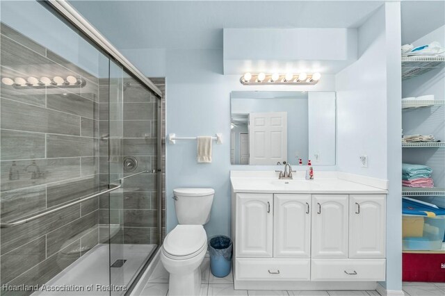 bathroom featuring toilet, vanity, and walk in shower