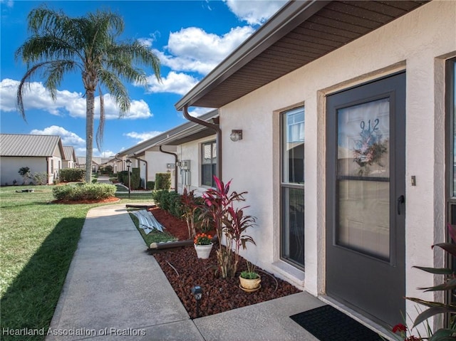 view of exterior entry featuring a yard