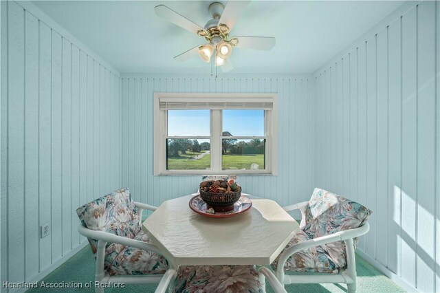 dining space featuring wood walls