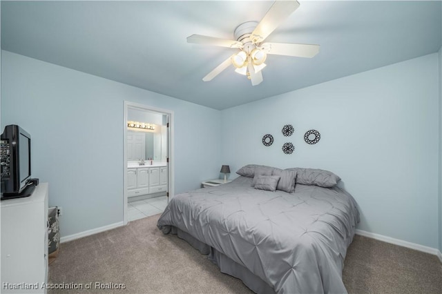 bedroom featuring light colored carpet, ensuite bath, and ceiling fan