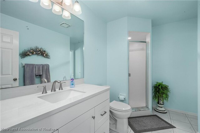 bathroom featuring vanity, an enclosed shower, and toilet