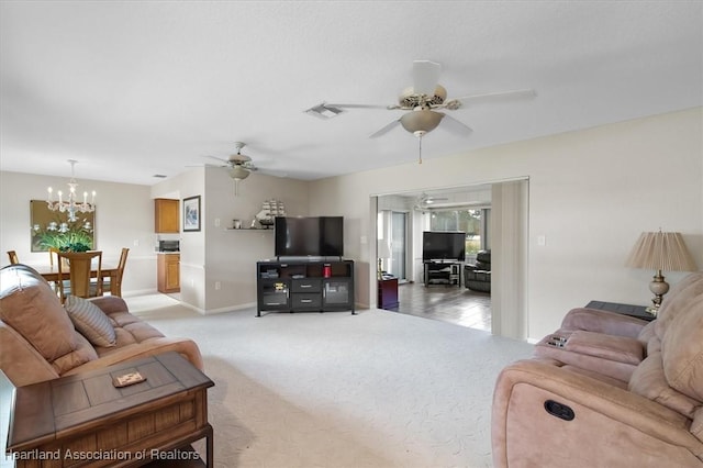 carpeted living room featuring ceiling fan with notable chandelier