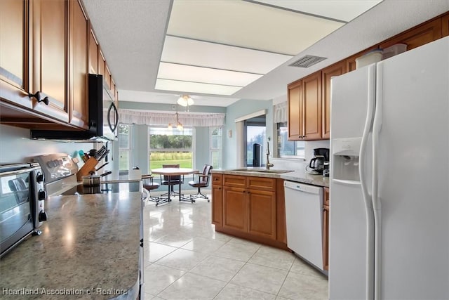 kitchen with sink, light tile patterned floors, pendant lighting, and white appliances