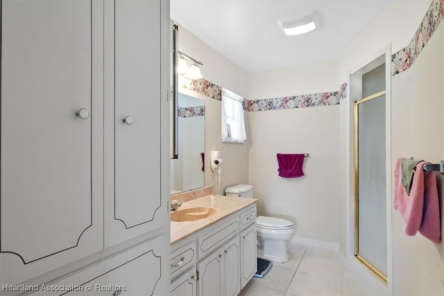 bathroom featuring tile patterned flooring, toilet, vanity, and walk in shower