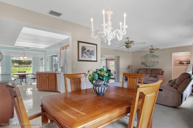 dining space with ceiling fan with notable chandelier and light tile patterned flooring