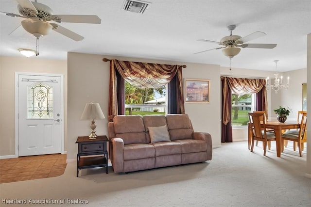 living room with ceiling fan with notable chandelier and light colored carpet