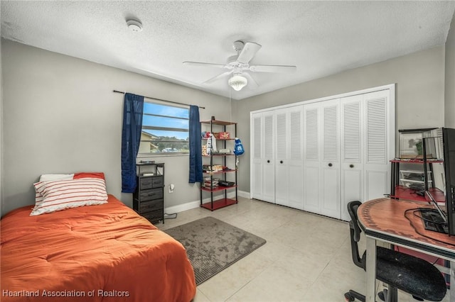 bedroom featuring a closet, ceiling fan, a textured ceiling, and baseboards