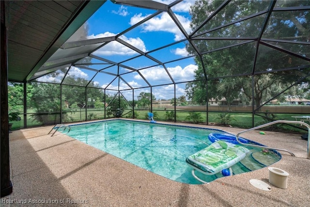 pool featuring glass enclosure and a patio area