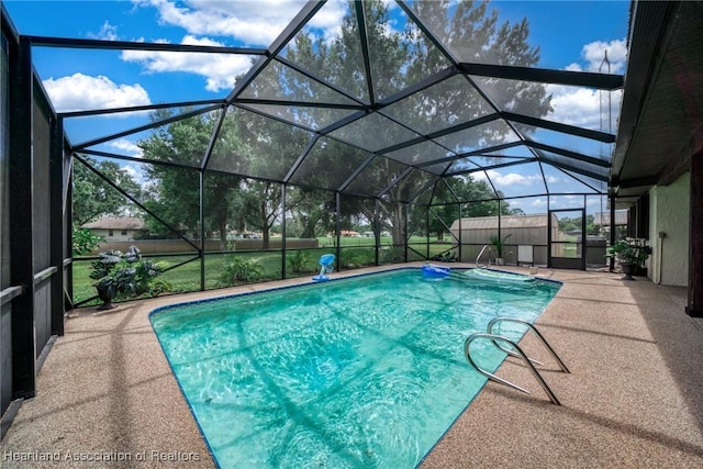 outdoor pool with glass enclosure and a patio area