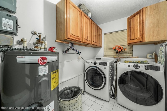 laundry room featuring light tile patterned floors, cabinet space, water heater, a textured ceiling, and separate washer and dryer