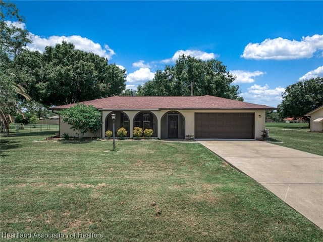 view of front of house with driveway, a front yard, a garage, and stucco siding