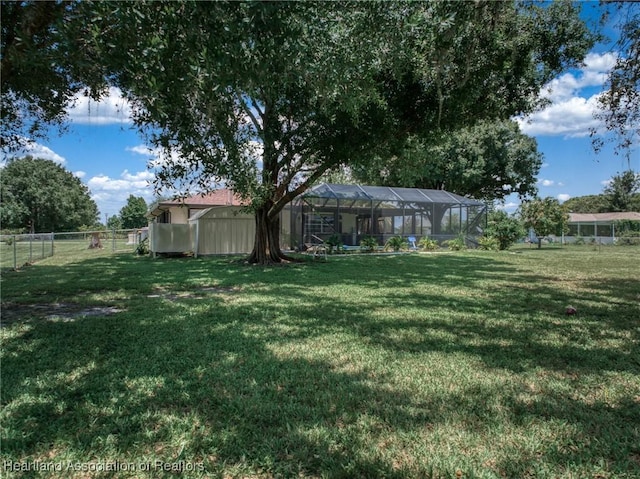 view of yard featuring a lanai and fence