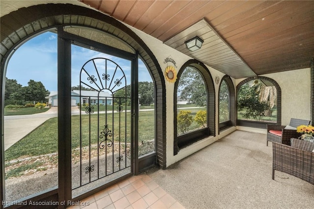 unfurnished sunroom with lofted ceiling and wood ceiling