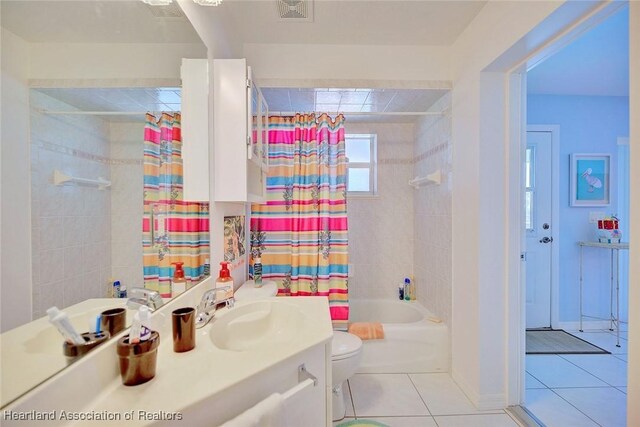 full bathroom featuring tile patterned flooring, vanity, shower / tub combo with curtain, and toilet