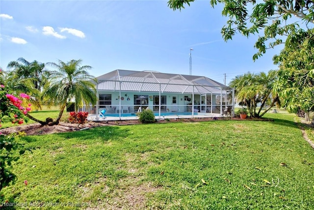 back of house featuring a yard and glass enclosure