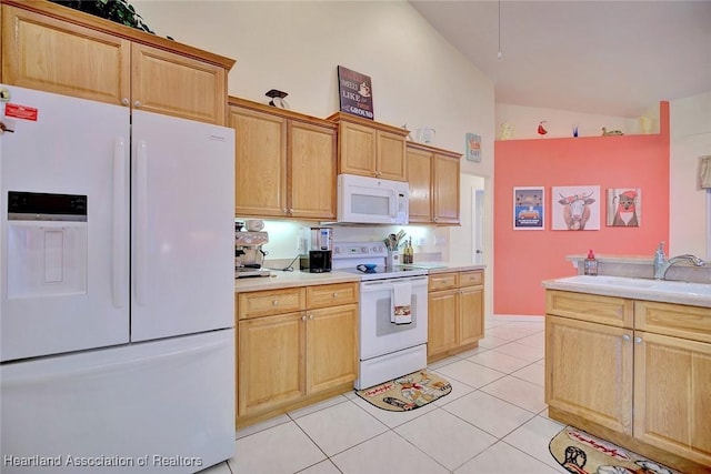 kitchen with light tile patterned flooring, vaulted ceiling, sink, light brown cabinets, and white appliances