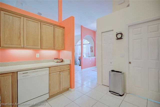 kitchen with light tile patterned flooring, light brown cabinetry, and white dishwasher