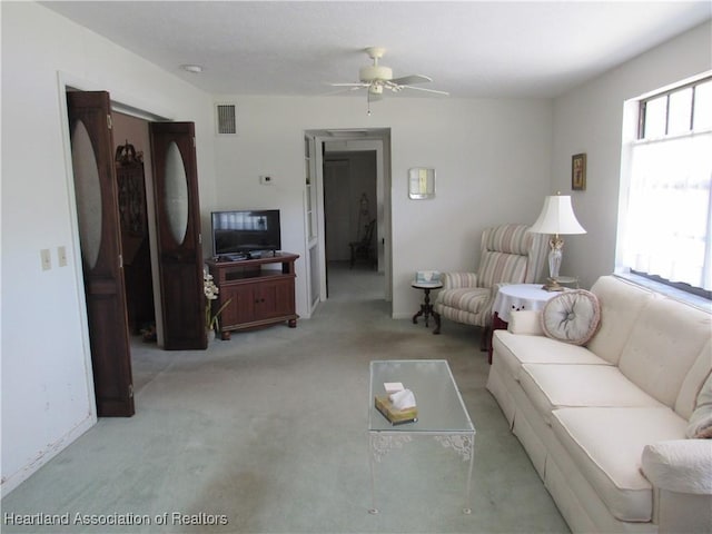 living area with carpet flooring, a ceiling fan, and visible vents