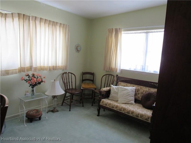 living area with plenty of natural light and carpet