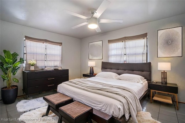 bedroom with multiple windows, tile patterned flooring, and a ceiling fan