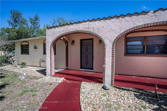 view of exterior entry featuring stucco siding