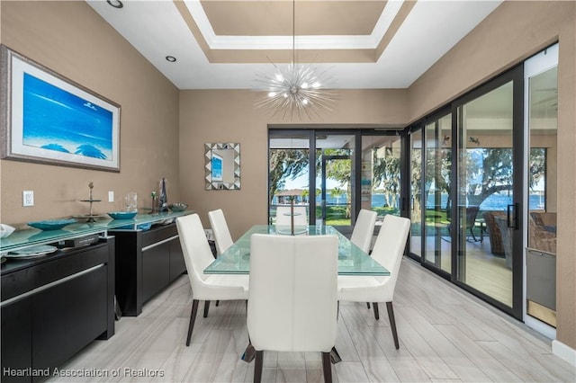 dining space featuring an inviting chandelier, a tray ceiling, and crown molding