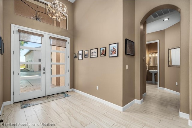 doorway to outside featuring light hardwood / wood-style floors, a chandelier, and french doors