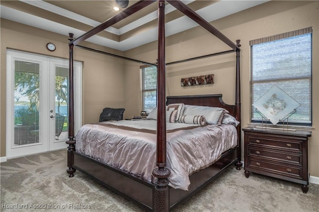 bedroom with access to outside, light carpet, and a tray ceiling