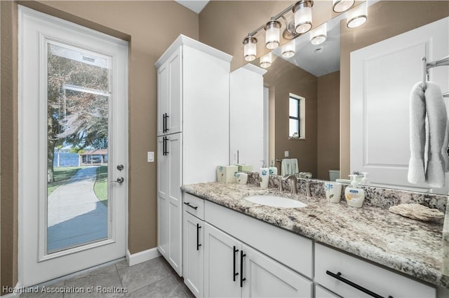 bathroom with vanity, a wealth of natural light, tile patterned floors, and toilet