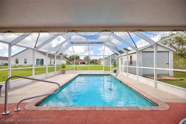 view of swimming pool featuring a lawn, glass enclosure, and a patio