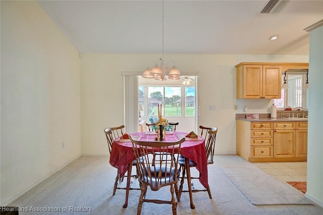 carpeted dining area featuring sink and an inviting chandelier