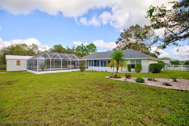 rear view of property featuring a lanai and a lawn