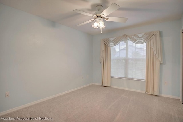 carpeted spare room with ceiling fan