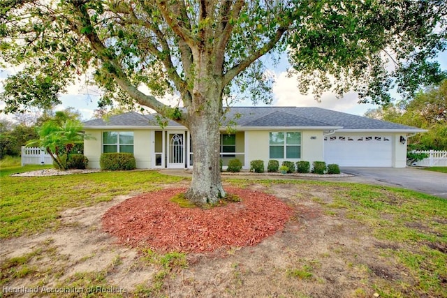 single story home featuring a garage and a front yard