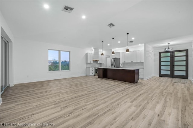 kitchen featuring white cabinetry, hanging light fixtures, a center island, and appliances with stainless steel finishes