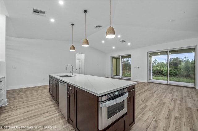 kitchen featuring lofted ceiling, sink, light hardwood / wood-style flooring, pendant lighting, and stainless steel appliances