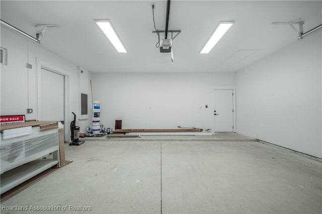 garage with a garage door opener and electric panel