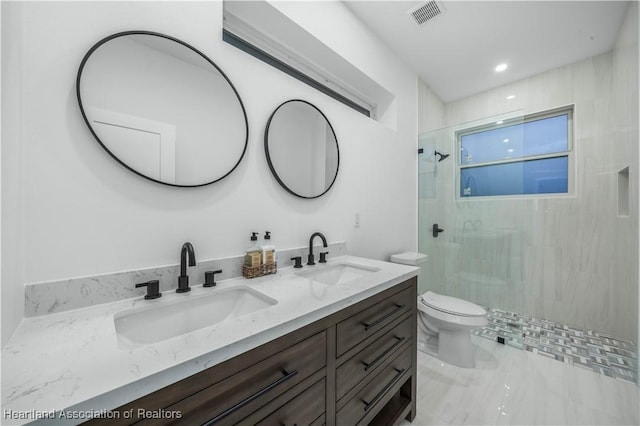 bathroom featuring vanity, toilet, and a shower with door