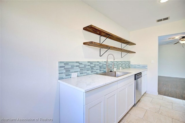 kitchen featuring tasteful backsplash, dishwasher, white cabinetry, sink, and ceiling fan