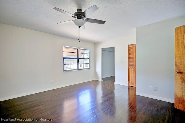 unfurnished room featuring ceiling fan, dark hardwood / wood-style floors, and a textured ceiling