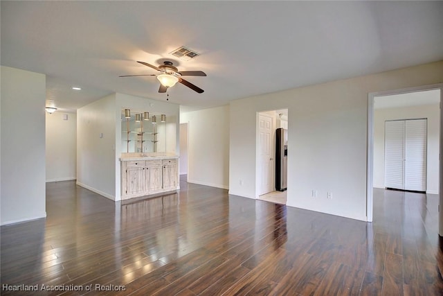 unfurnished living room with ceiling fan and dark hardwood / wood-style flooring