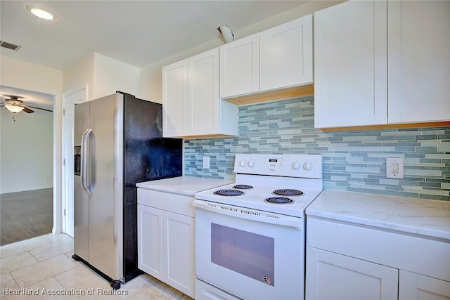 kitchen featuring light tile patterned floors, stainless steel fridge, ceiling fan, white electric range oven, and white cabinets