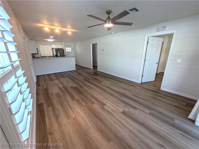 unfurnished living room featuring ceiling fan and dark hardwood / wood-style floors