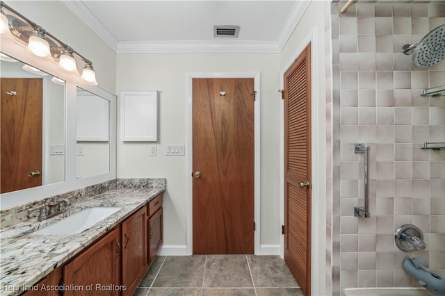 bathroom featuring crown molding, vanity, and tiled shower