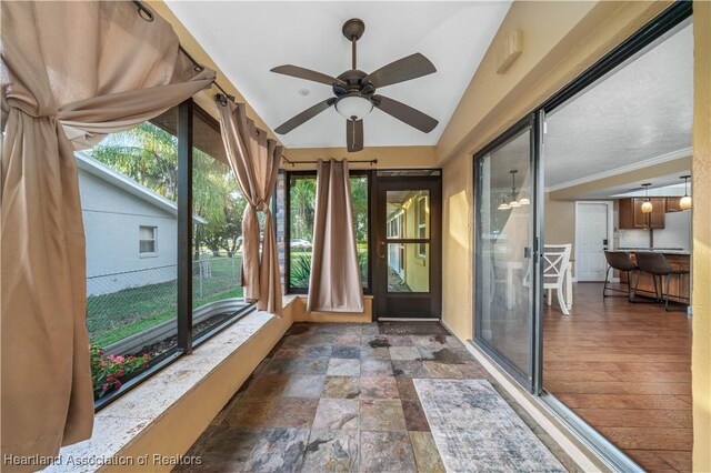 unfurnished sunroom with ceiling fan and lofted ceiling