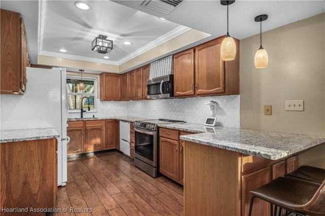 kitchen with kitchen peninsula, appliances with stainless steel finishes, dark hardwood / wood-style flooring, a kitchen breakfast bar, and pendant lighting