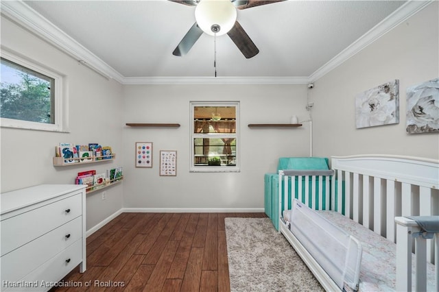 bedroom with ceiling fan, a nursery area, dark wood-type flooring, and ornamental molding