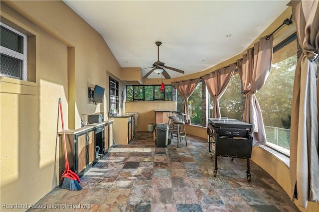 sunroom featuring ceiling fan